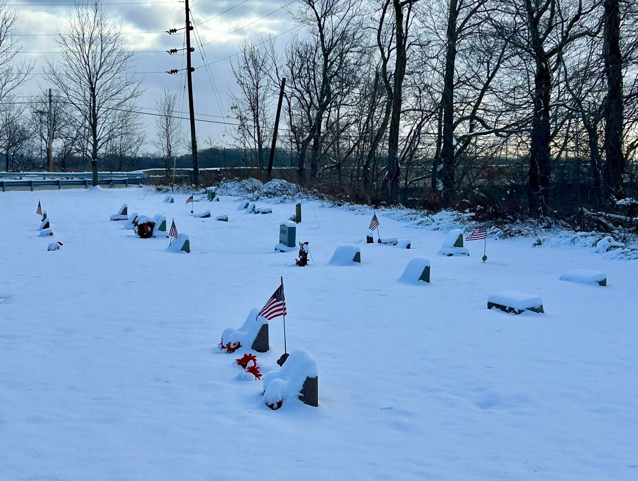 Flags and flowers beside grave markers